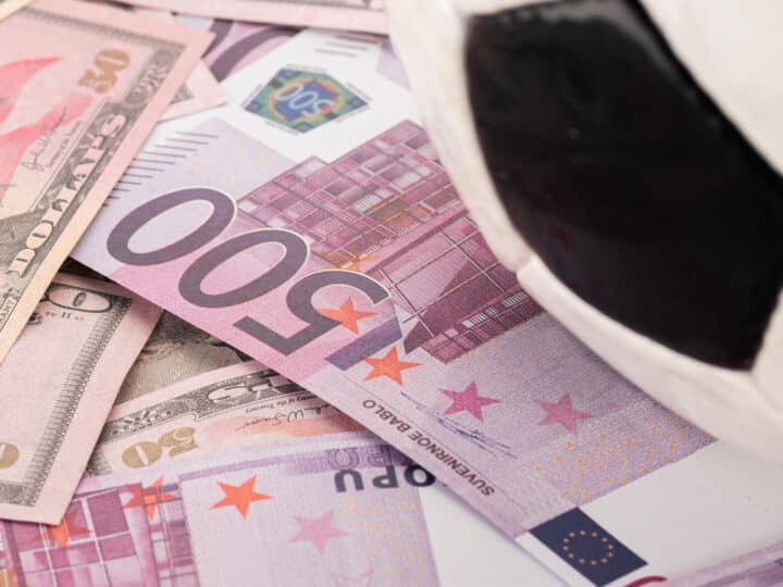 close up view of soccer ball on euro and dollar banknotes, sport