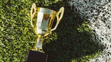 golden-champion-cup-on-football-field-corner-even-2022-12-16-21-58-37-utc