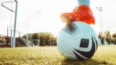 Professional football kicking ball in soccer stadium – Athletic