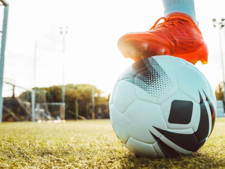 Professional football kicking ball in soccer stadium – Athletic